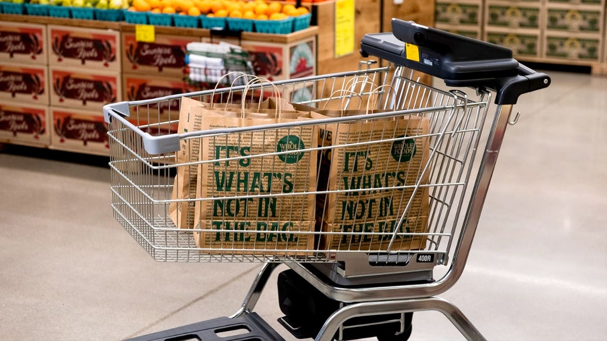 An Amazon Dash Cart is filled with Whole Foods grocery bags.