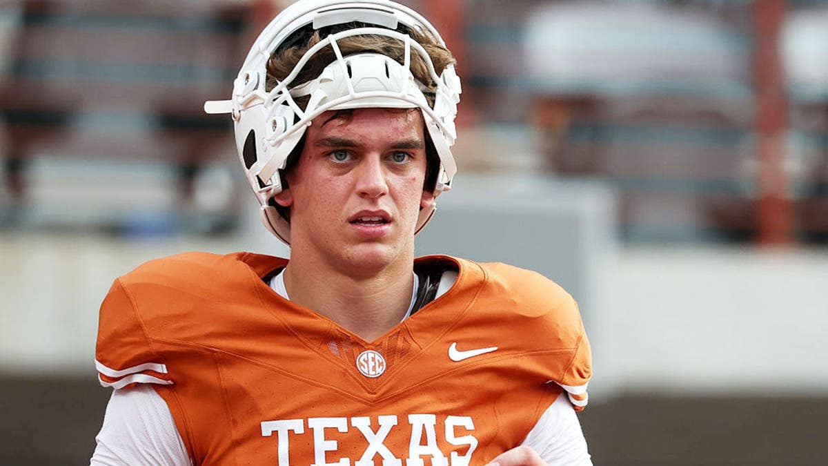 Arch Manning stands on the field during warmups before a college football game in Austin, Texas.