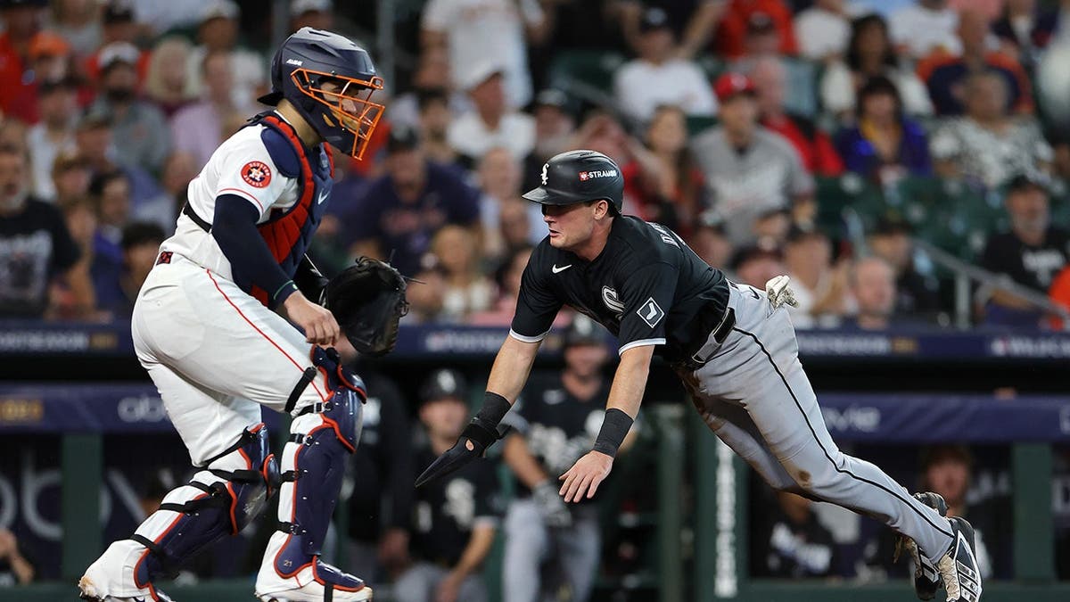 Sam Antonacci slides into home plate past Yainer Diaz during the first inning of the American League Wild Card Series.