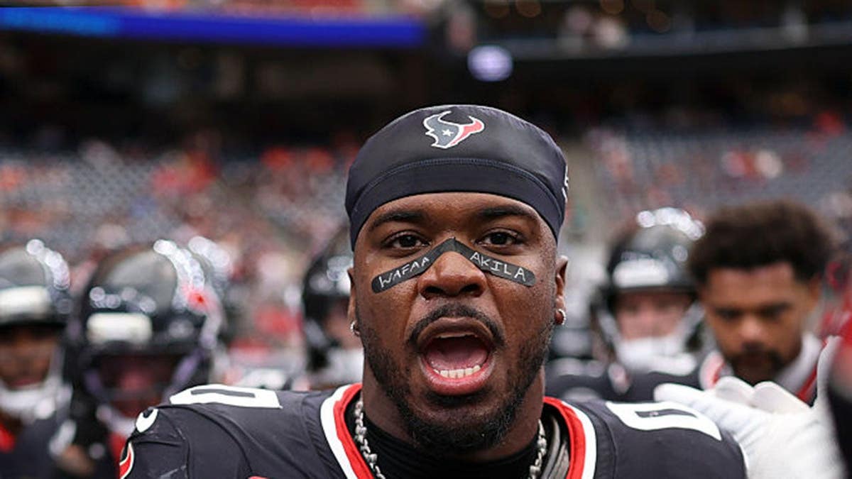 Azeez al-Shaair stands in a team huddle before an NFL game in Houston.