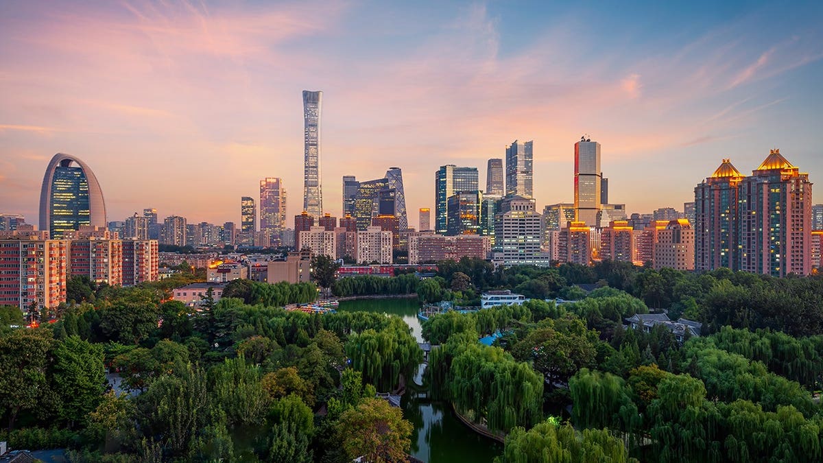 Beijing skyline silhouetted against a glowing sunset.