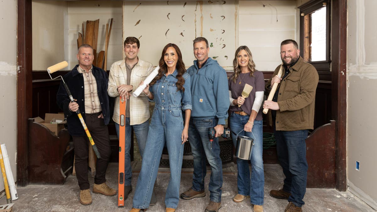 "Betting on Beloit" renovation crew pose with tools inside a room under construction.