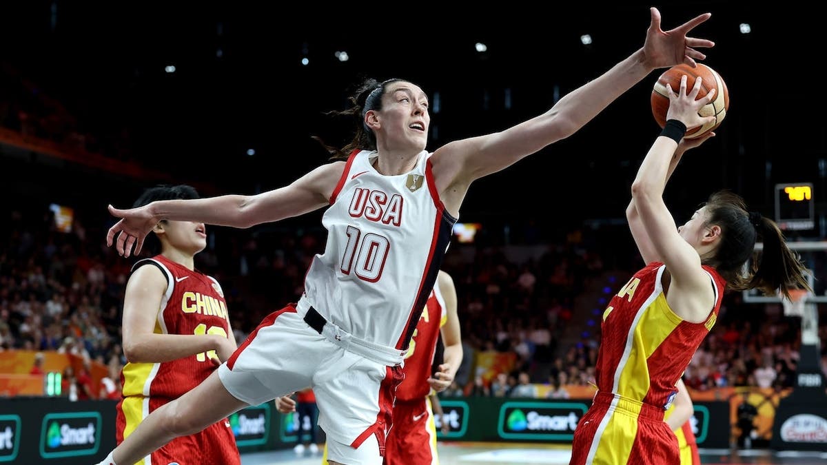 Breanna Stewart of USA challenges Manman Zhang of China during a basketball game.
