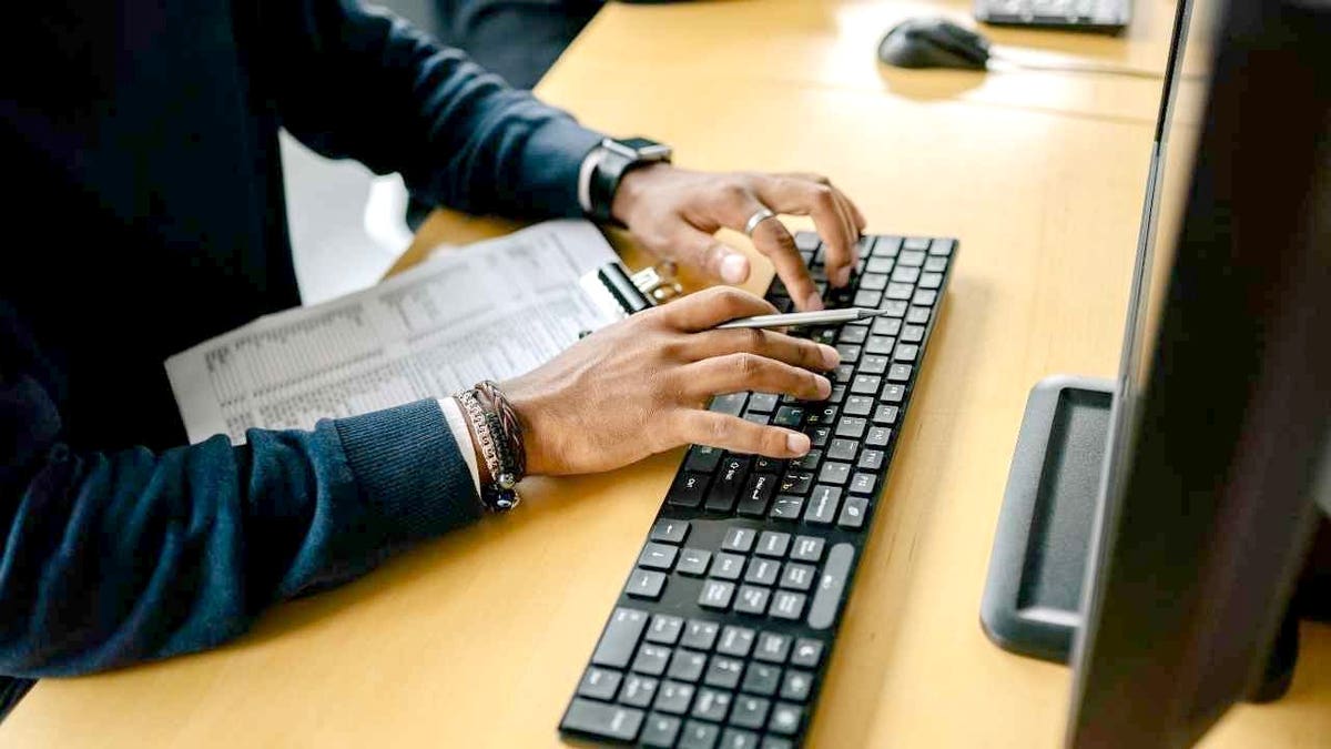 A man types on a keyboard.