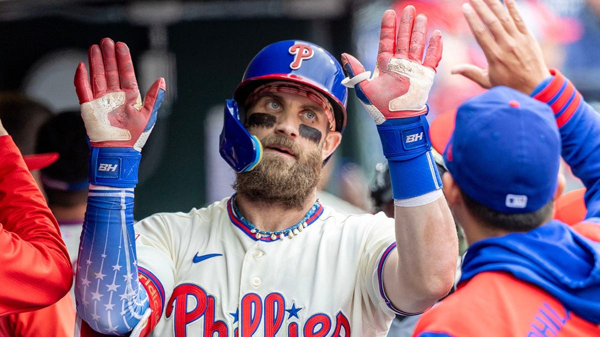 Bryce Harper is cheered in the dugout after hitting a solo home run.
