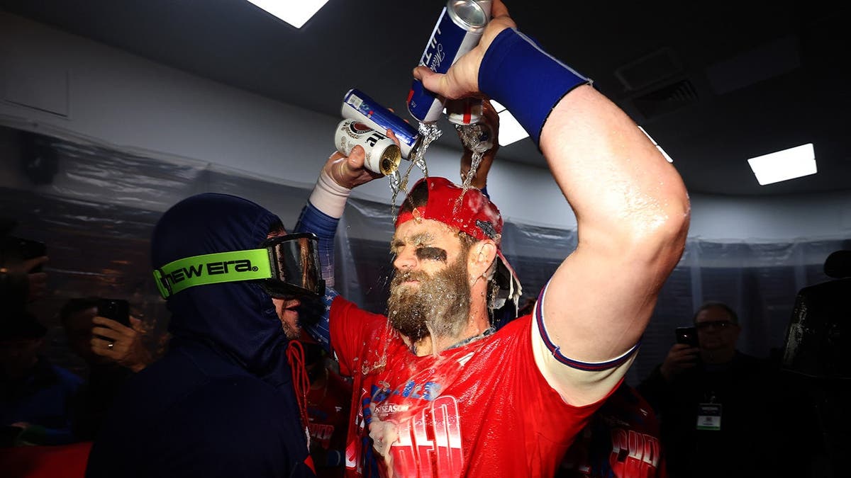 Bryce Harper and Trea Turner celebrate in the Philadelphia Phillies clubhouse.
