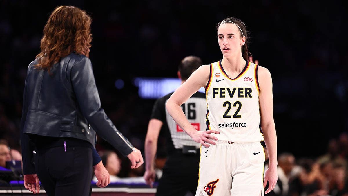 Caitlin Clark speaks with head coach Stephanie White during a WNBA playoff game.
