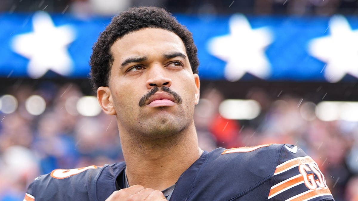 Caleb Williams stands on the sideline during the national anthem at Soldier Field.