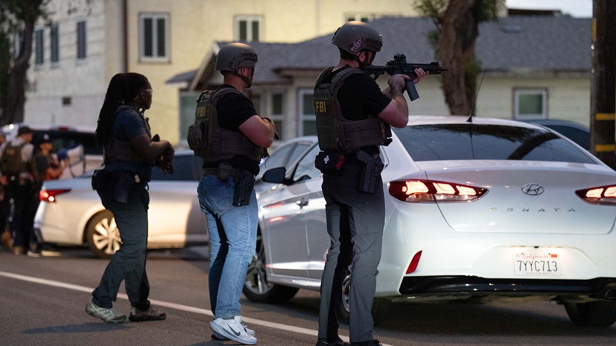 FBI agents stand outside Lakiya Malone's home in Los Angeles.