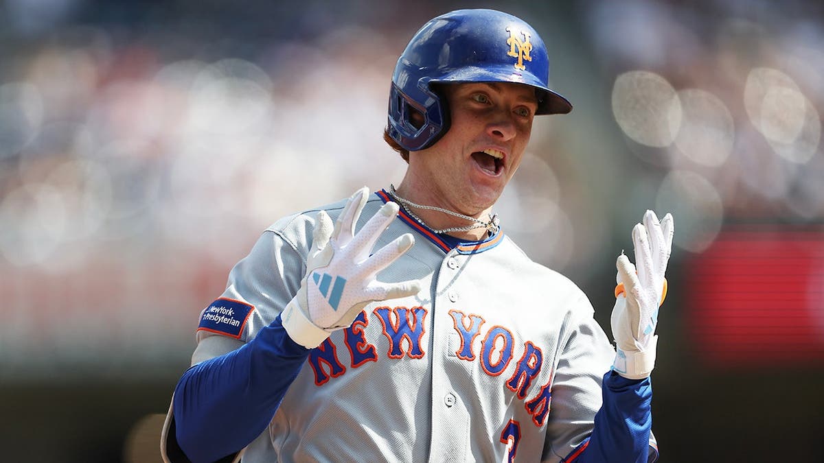 Carson Benge gestures while rounding the bases after hitting a home run during a baseball game.