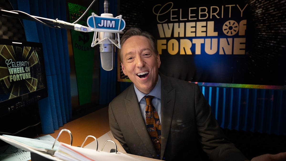 Ilana Glazer, Chelsea Peretti and Moshe Kasher stand on the Celebrity Wheel of Fortune set.