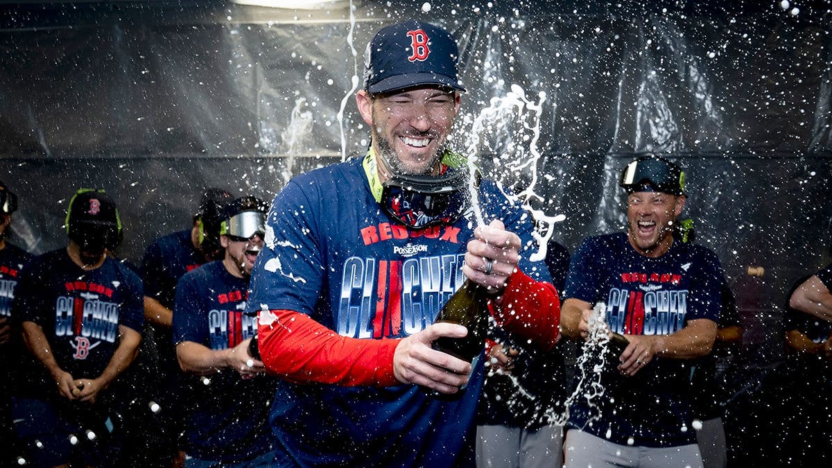 Chad Tracy celebrates with champagne in the clubhouse after clinching a playoff berth.