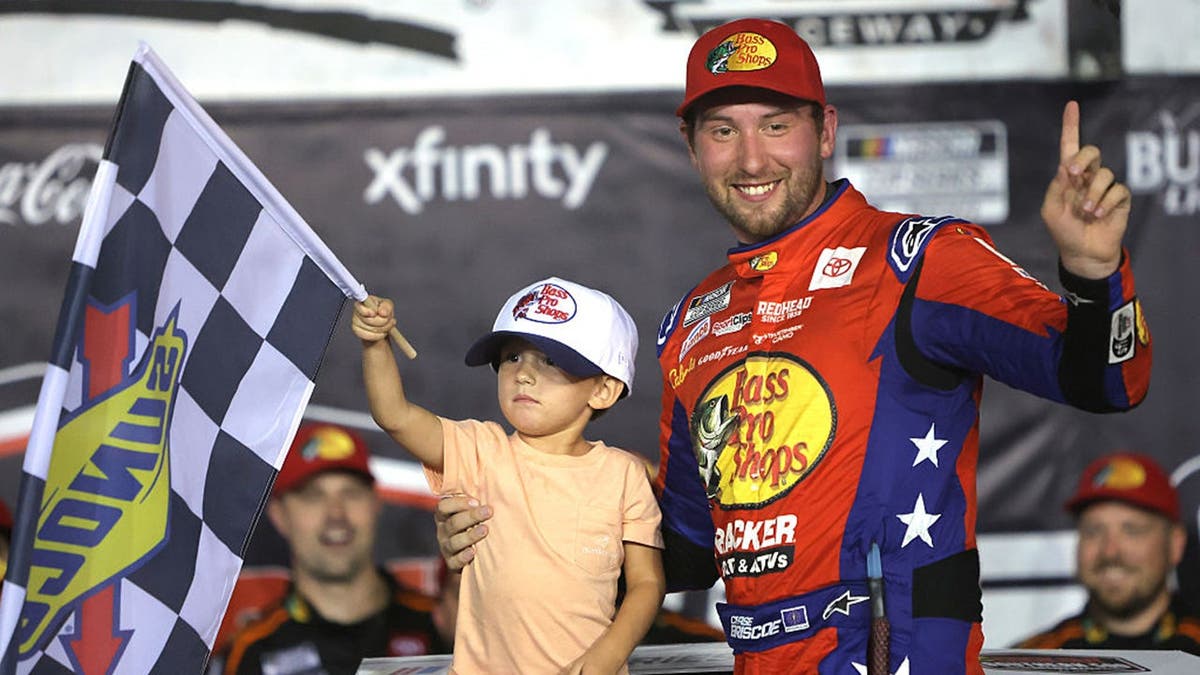 Chase Briscoe celebrates with his son Brooks after winning a NASCAR race.