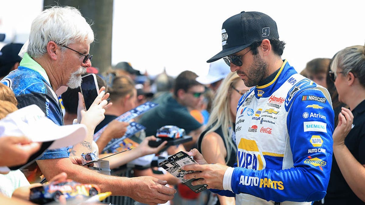 Chase Elliott signs autographs for NASCAR fans before the Brickyard 400.