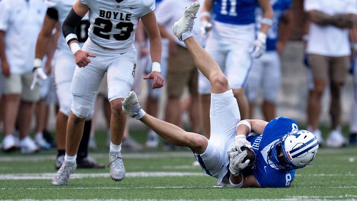 Chase Jacob, wide receiver, catches a pass as Lucas Akers defends during a football game.