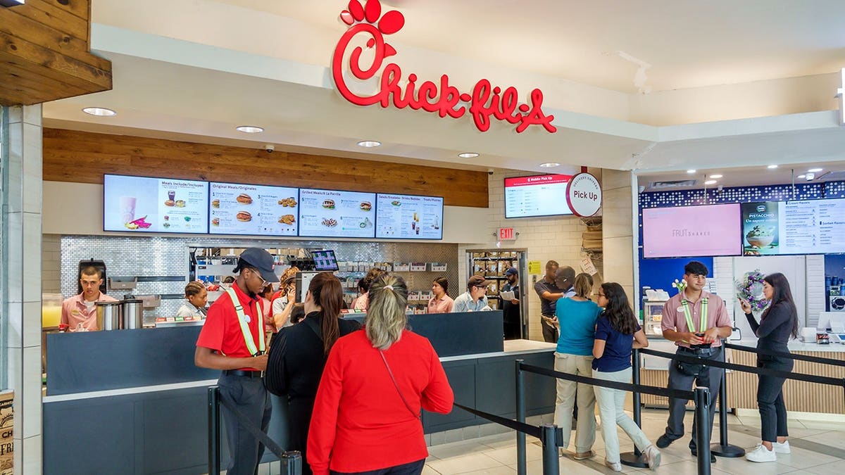 Employee takes an order from a customer at Chick-fil-A in a food court.