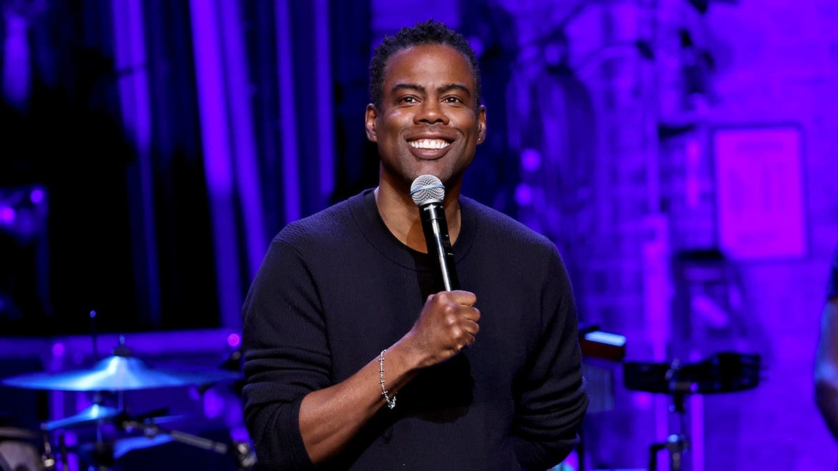Chris Rock performs onstage with a microphone at Beacon Theatre.