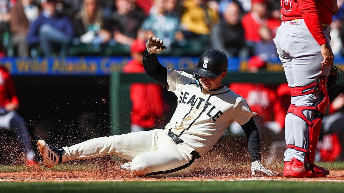 Cole Young of the Seattle Mariners slides into home plate at T-Mobile Park.