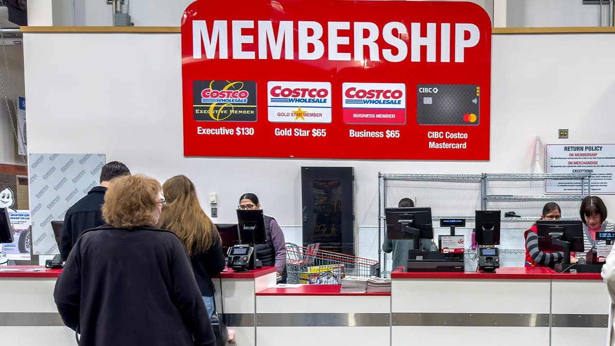 Customers stand in line at Costco's membership counter.
