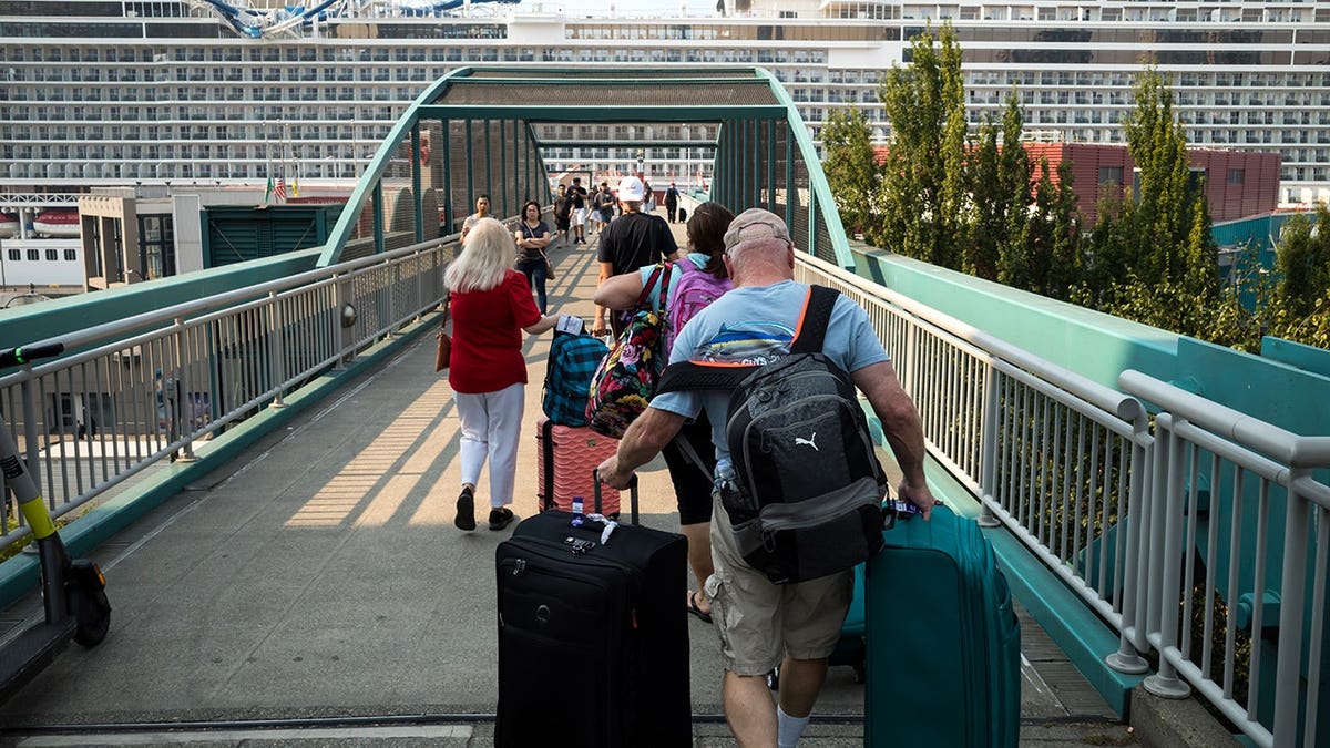 Cruise ship passengers walk toward Pier 66 in Seattle.