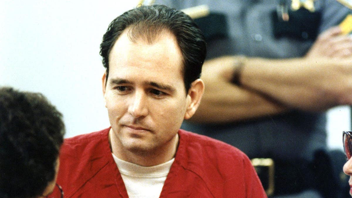 Danny Rolling talks with defense attorney Billy Nolas during his trial in a courtroom.