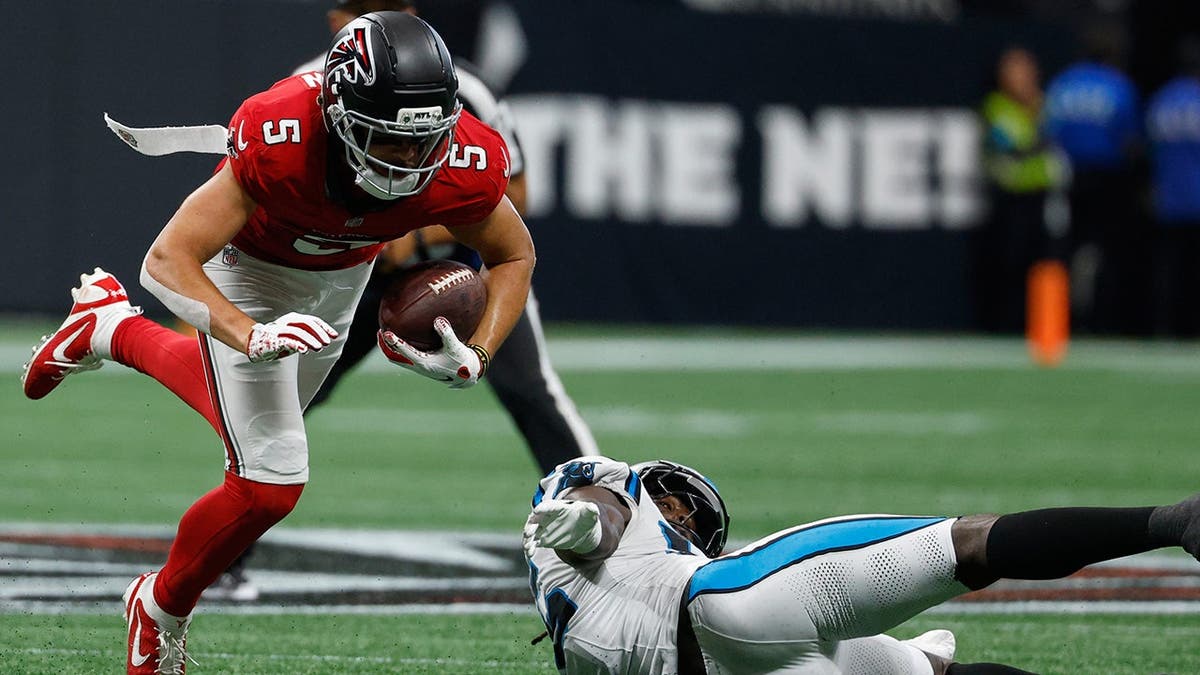 Devin Lloyd tackles Drake London during NFL game in Atlanta.
