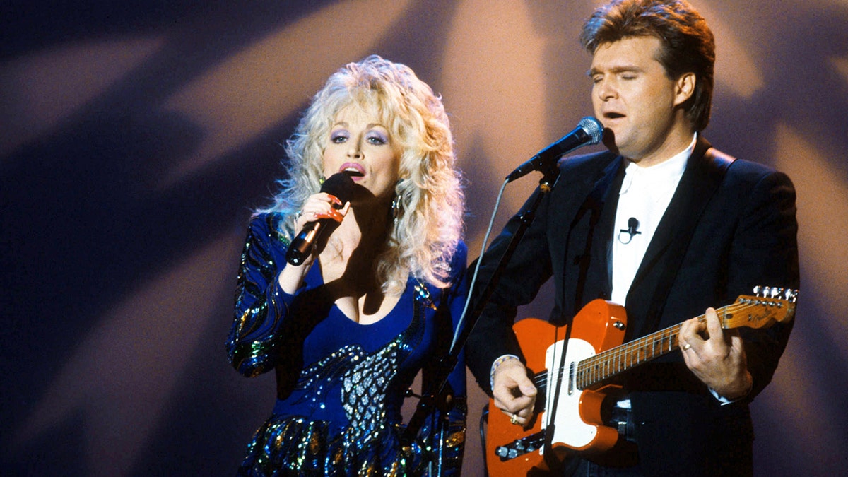 Dolly Parton, Ricky Skaggs on stage performing together.