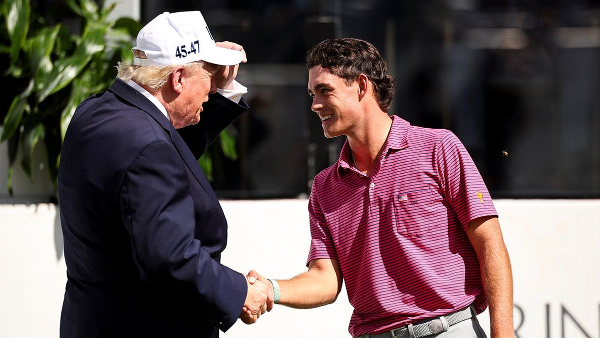 Donald Trump talks with Jackson Koivun on the golf course.