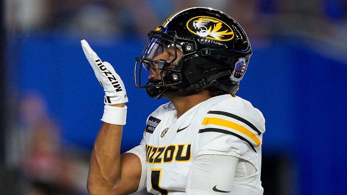Donovan Olugbode celebrates after scoring a touchdown during a college football game.