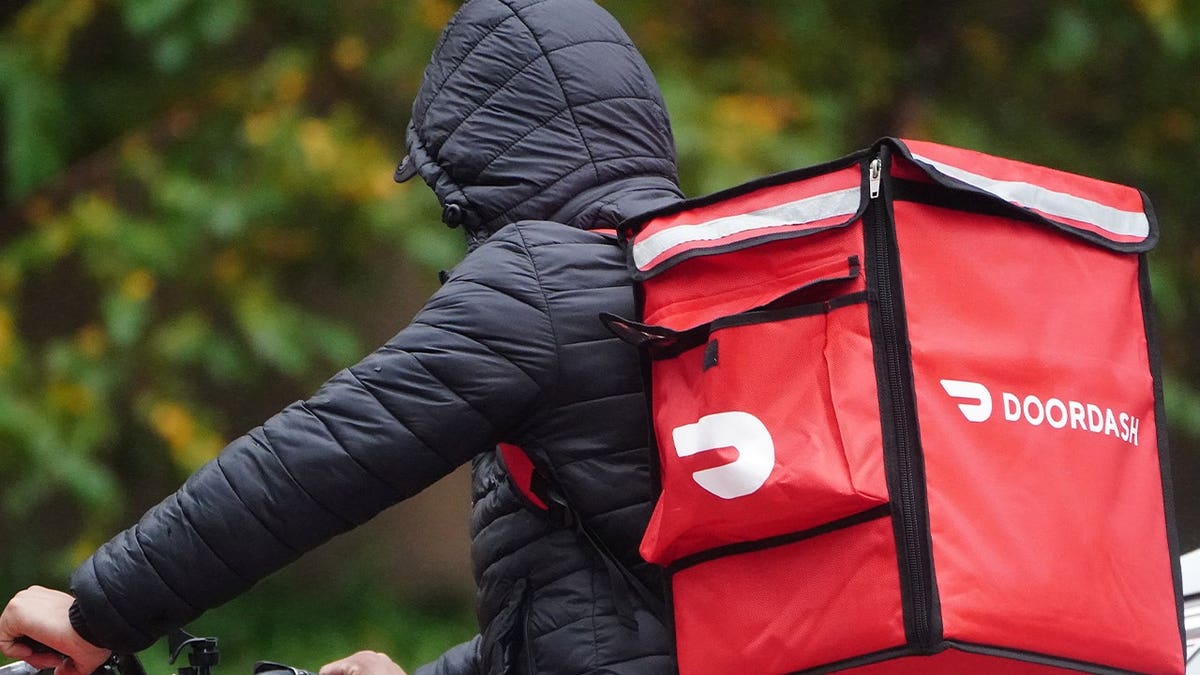 A delivery person for Doordash rides his bike in the rain in the Manhattan borough of New York City, New York on November 13, 2020.