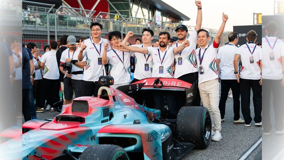 A group of people gathered around a racecar