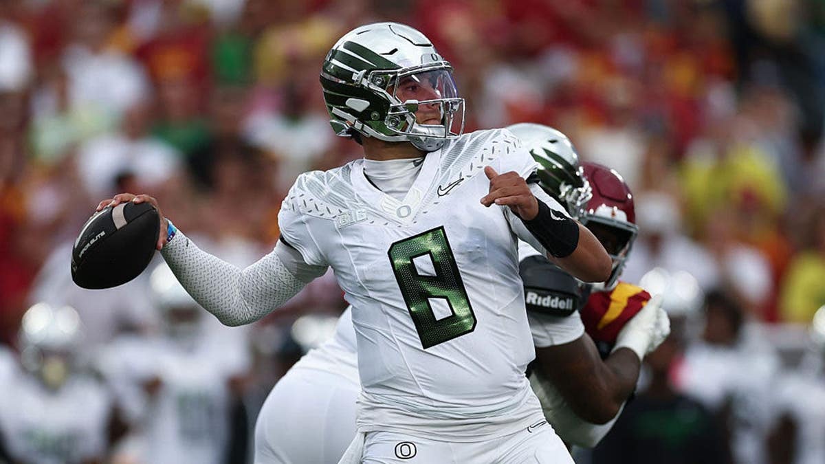 Dylan Raiola, quarterback for Oregon Ducks, throws the ball during a game against USC Trojans.