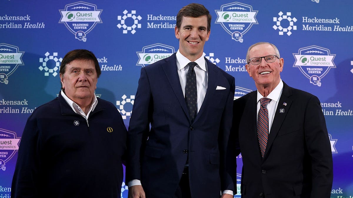 Eli Manning, Ernie Accorsi and Tom Coughlin pose together at a press conference.