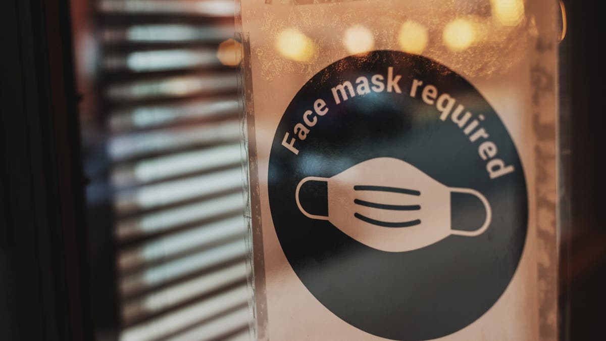 Face mask required sign on a restaurant entry door.