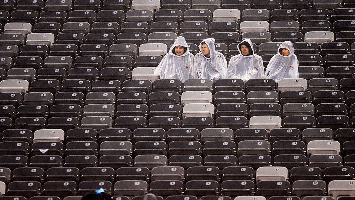 Fans sit in the rain during a Giants-Redskins game at MetLife Stadium.