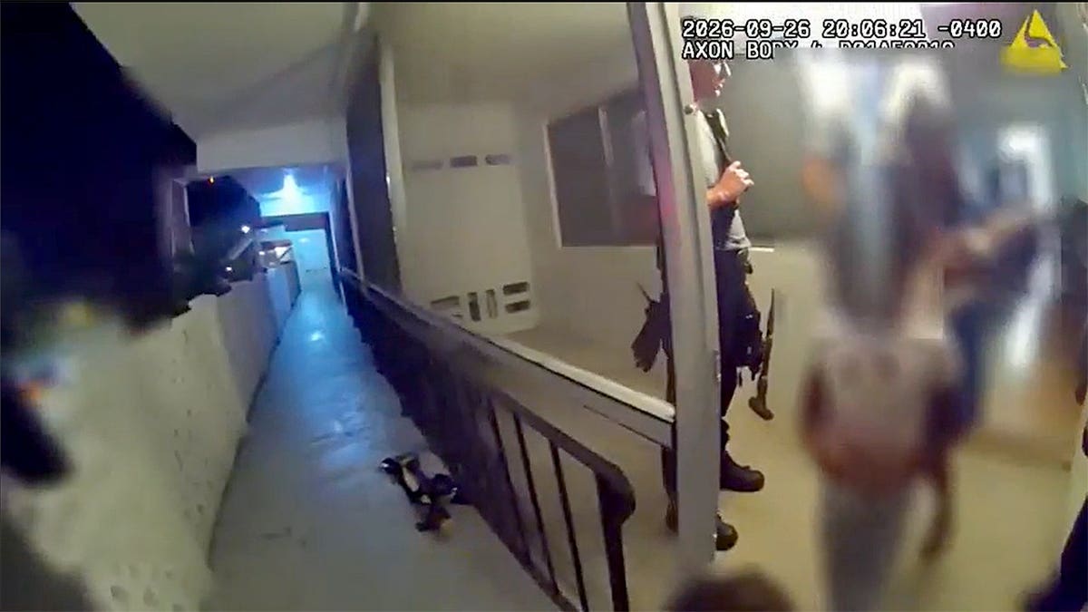 blurred faces of children ushered out of an apartment by police