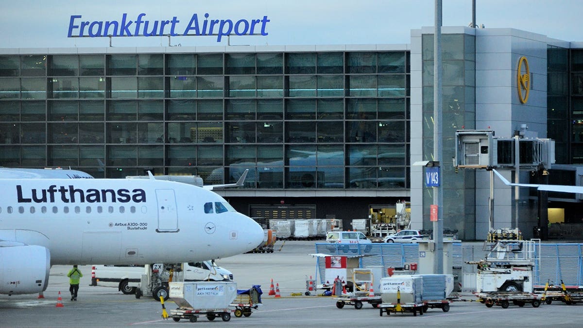 Lufthansa Airbus A320 parked at Remote Stand V143 at Frankfurt Airport terminal.