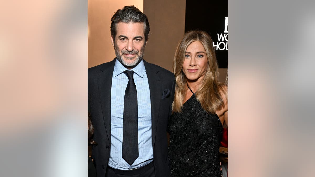 Jim Curtis and Jennifer Aniston pose together at an event in Los Angeles.