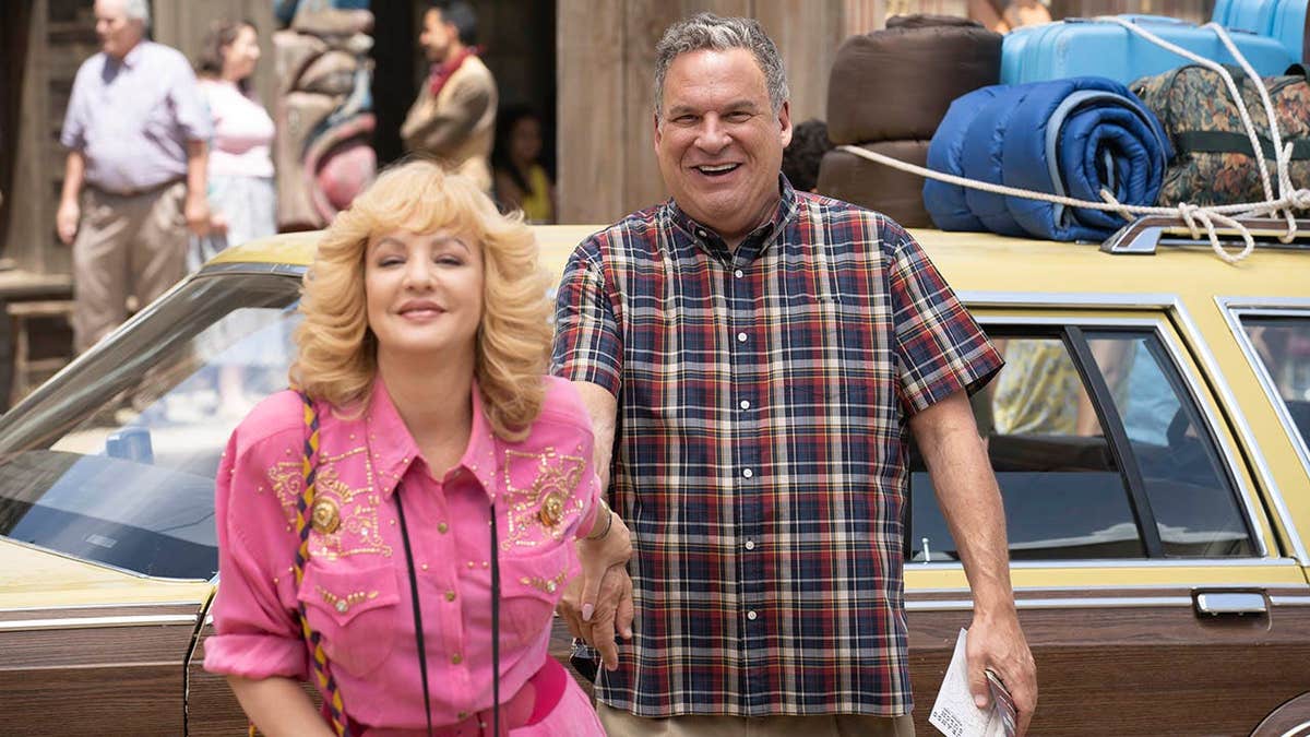 Wendi McLendon-Covey and Jeff Garlin stand together in a scene from The Goldbergs.