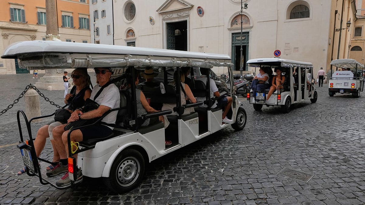 Golf carts carrying tourists travel past the Basilica of Santa Maria sopra Minerva in Rome.