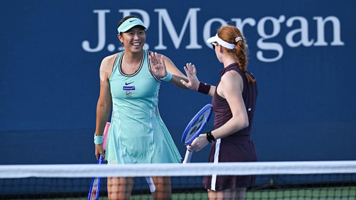 Hao-Ching Chan and Maya Joint high five during a women's doubles match.