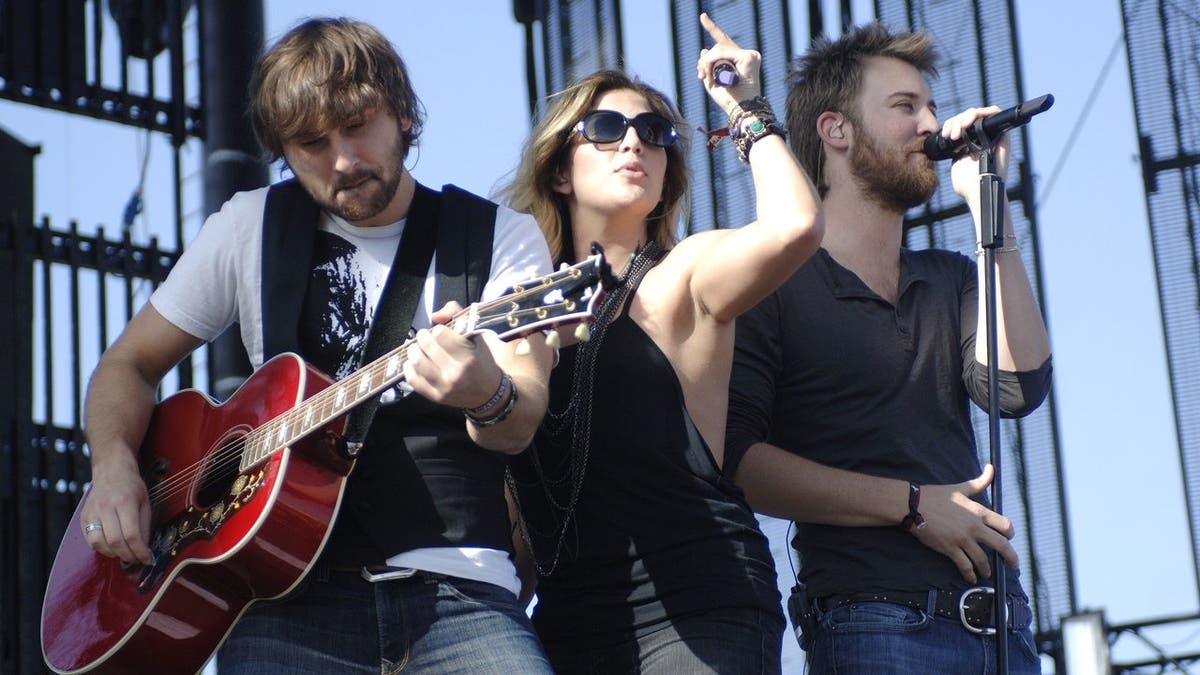 Dave Haywood, Hillary Scott and Charles Kelley perform onstage at a music festival.