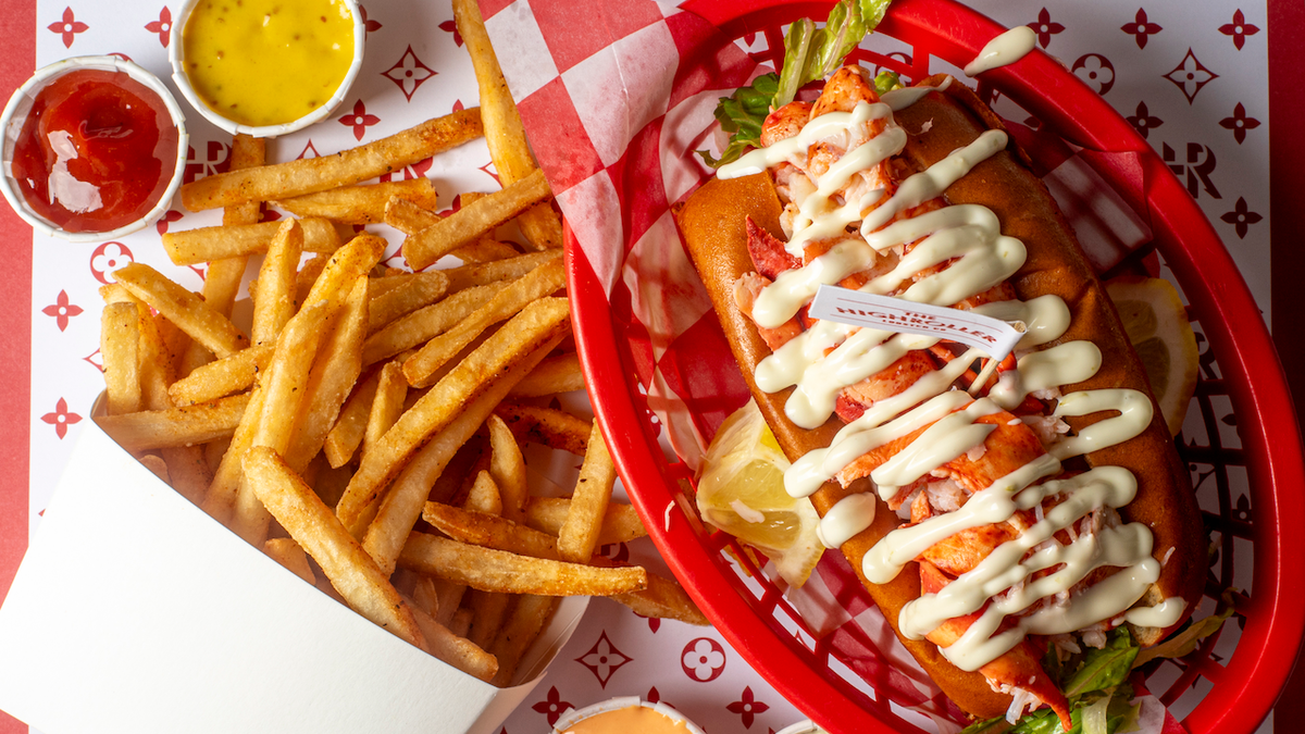 Basket with fries and a lobster roll topped with mayonnaise