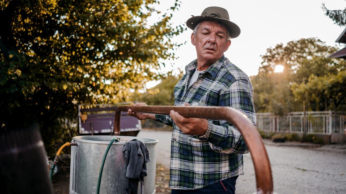 A man distills his own liquor.