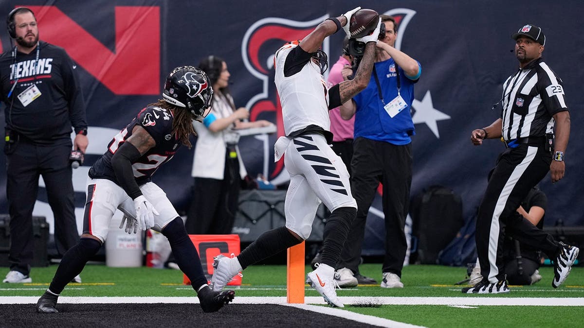 Ja'Marr Chase catches a touchdown pass as Derek Stingley Jr. looks on during an NFL game.