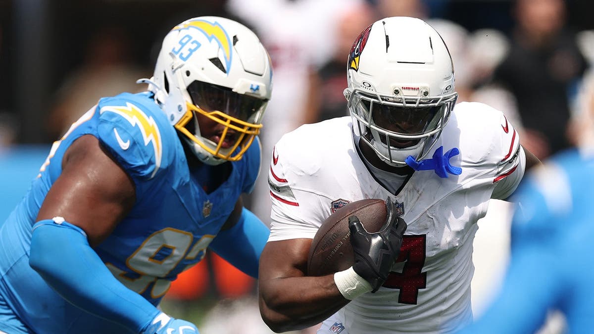 Jeremiyah Love, number 4, runs the ball against Teair Tart during an NFL game at SoFi Stadium.