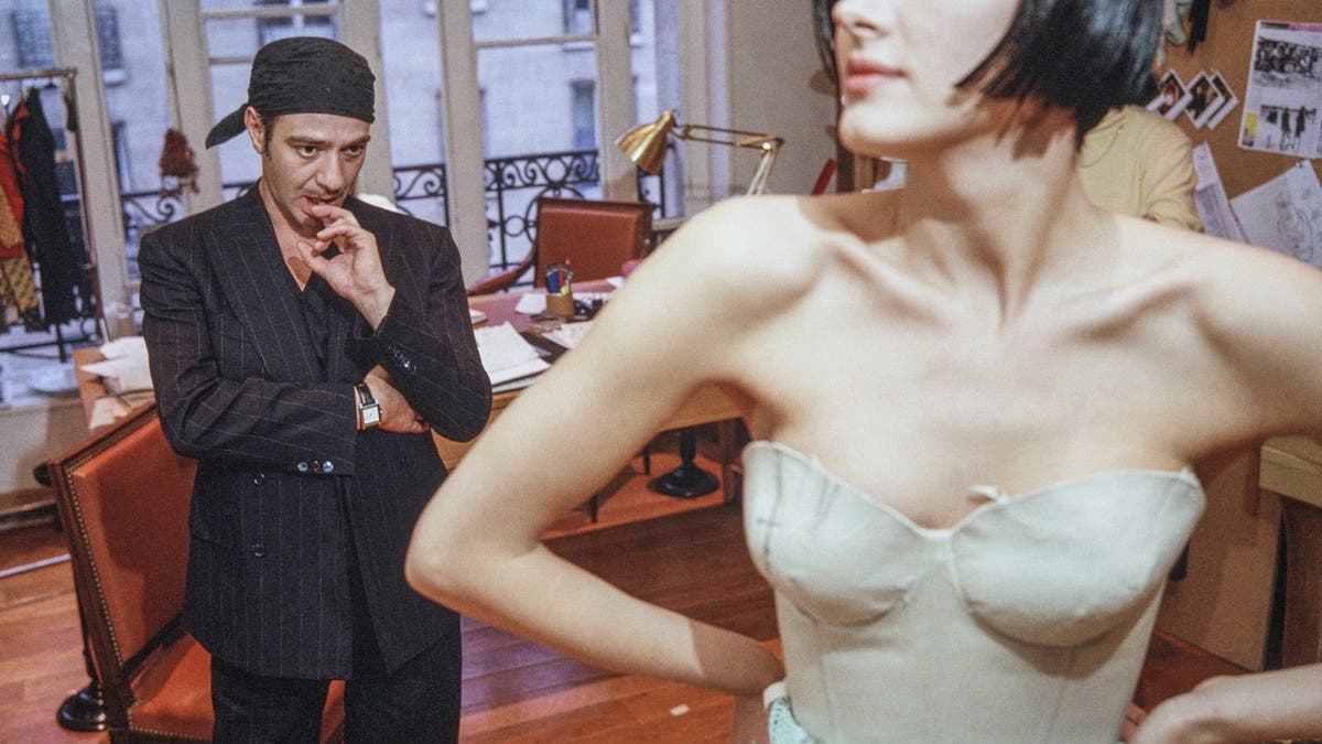 John Galliano works with a fashion model and assistants during a fitting session in the Christian Dior atelier.