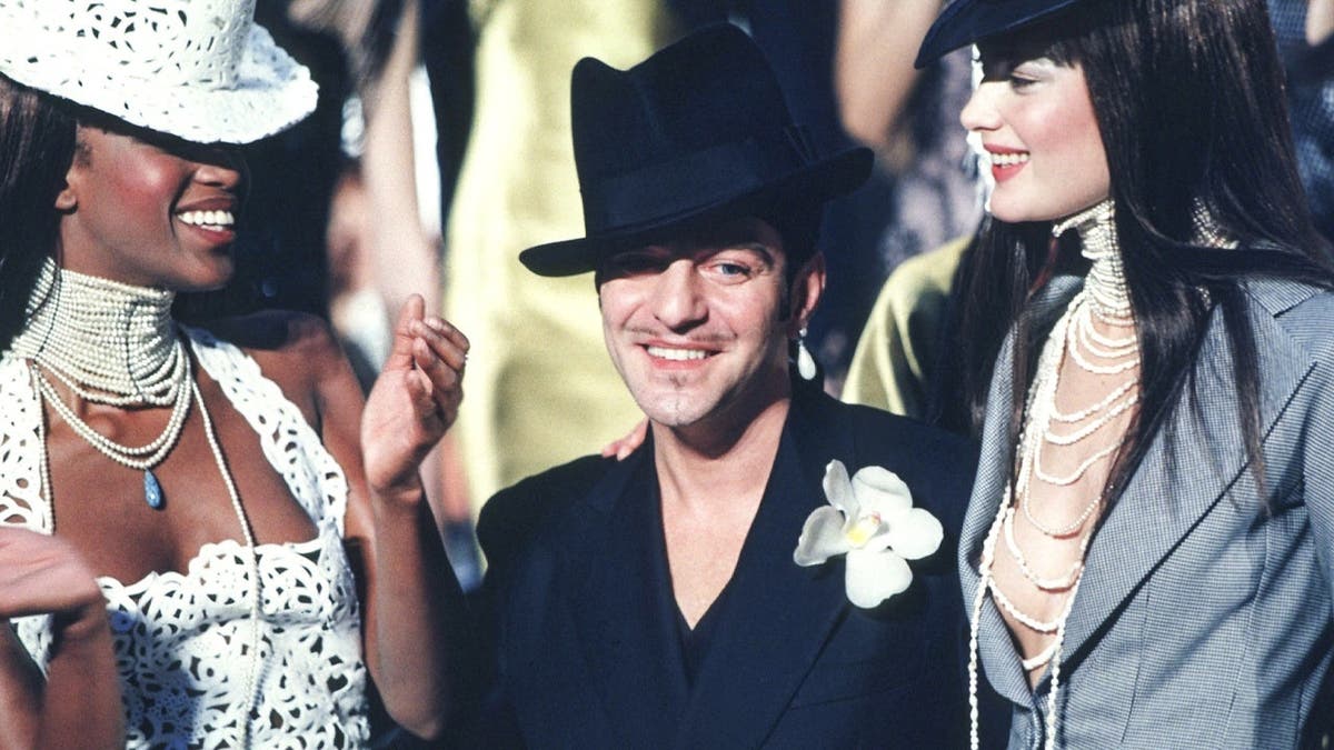 John Galliano works with a model and assistants during a fitting session in Paris.