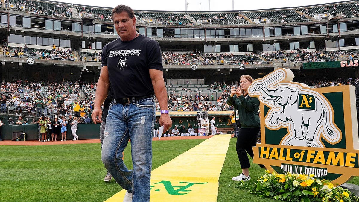 Jose Canseco walks onto the field at Oakland Coliseum during his Hall of Fame induction ceremony.