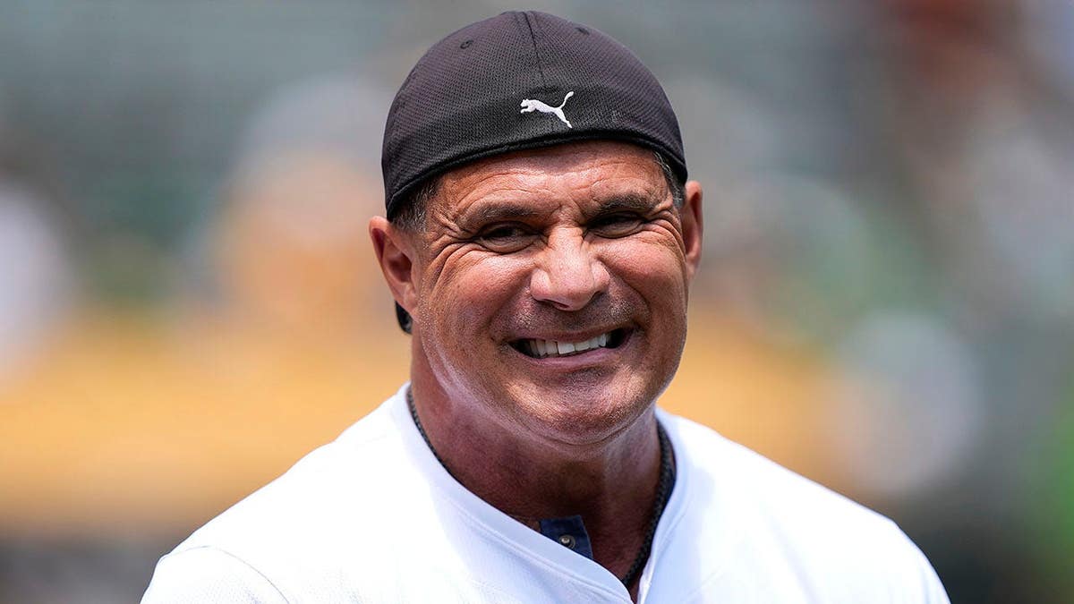 Jose Canseco stands on the field before a game at Oakland Coliseum.